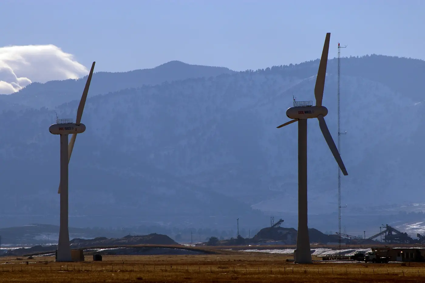 Two research wind turbines stand against snowy hills in Colorado.