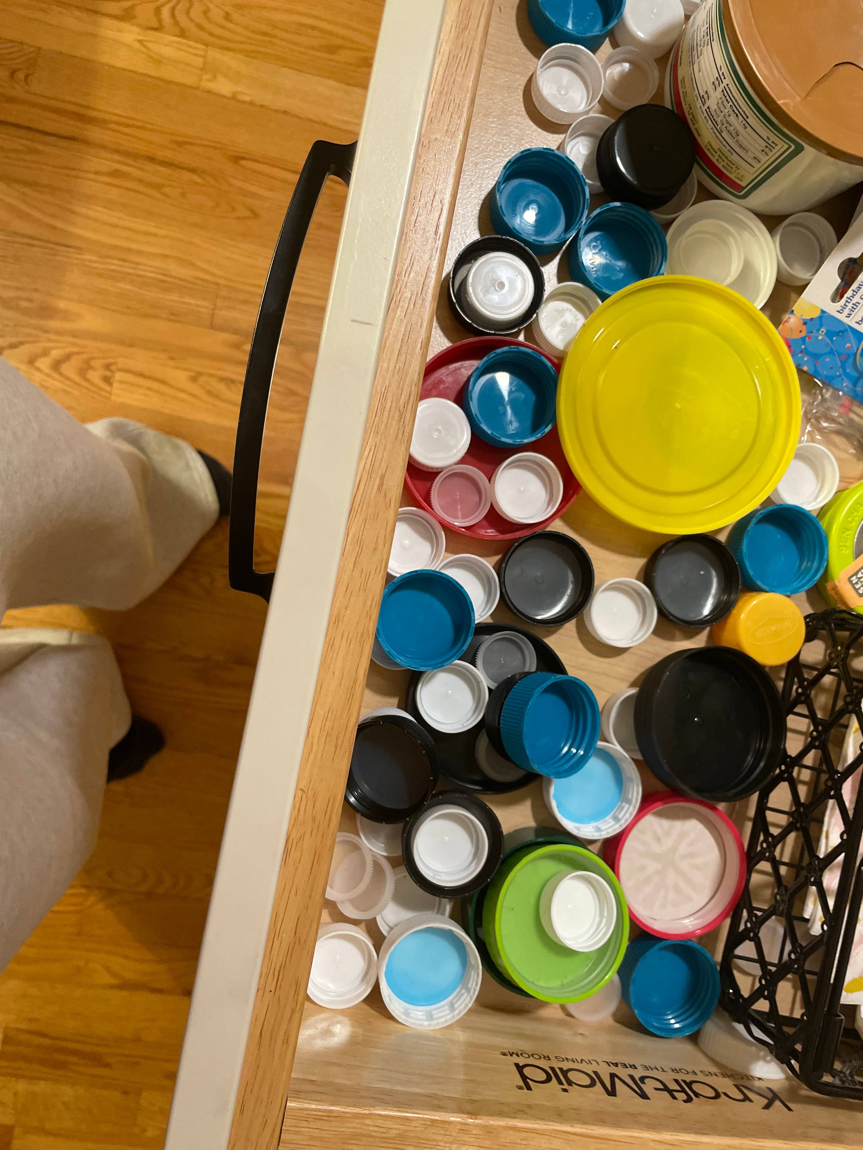 A drawer of plastic bottle caps and lids sorted for the mural project